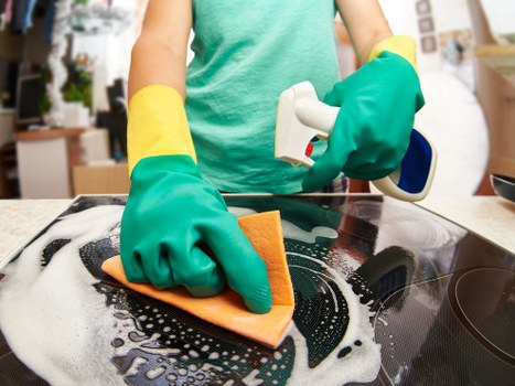 Cleaner in Brixton dusting and sanitizing a modern apartment